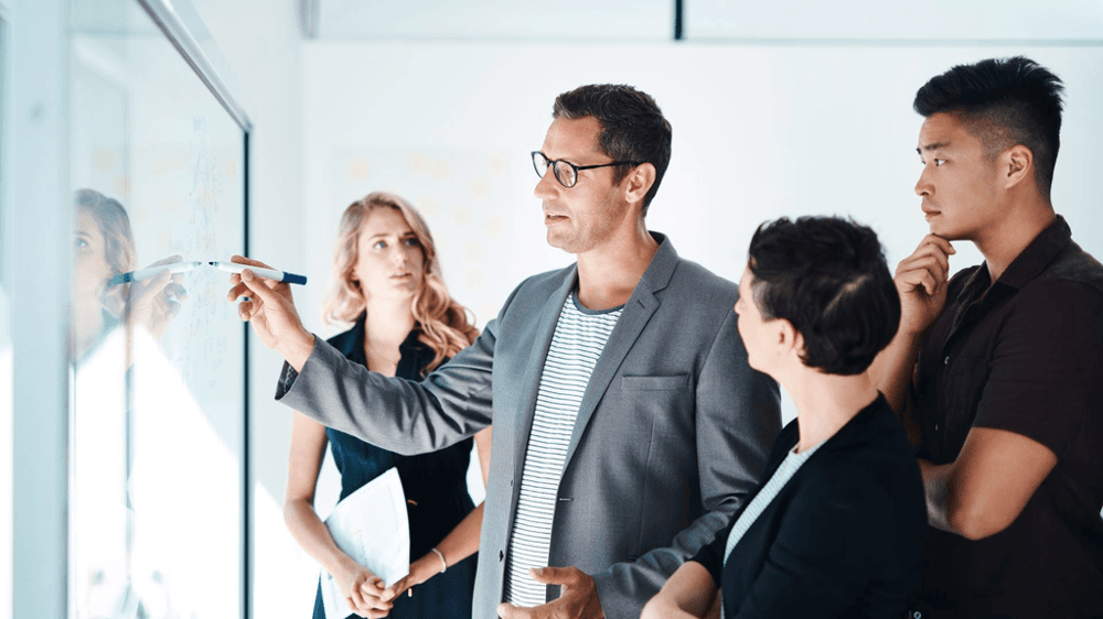 Insourcing Definition: Ein Team von Fachleuten diskutiert aktiv über Insourcing-Strategien an einem runden Konferenztisch im Büro.