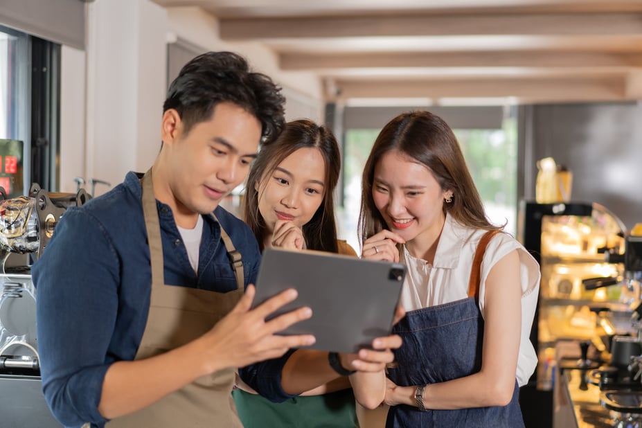 Team of employees discussing shift preferences while looking at schedule on a tablet