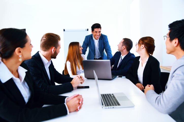 Arbeitgeber bespricht Leistungszulagen im Teammeeting.