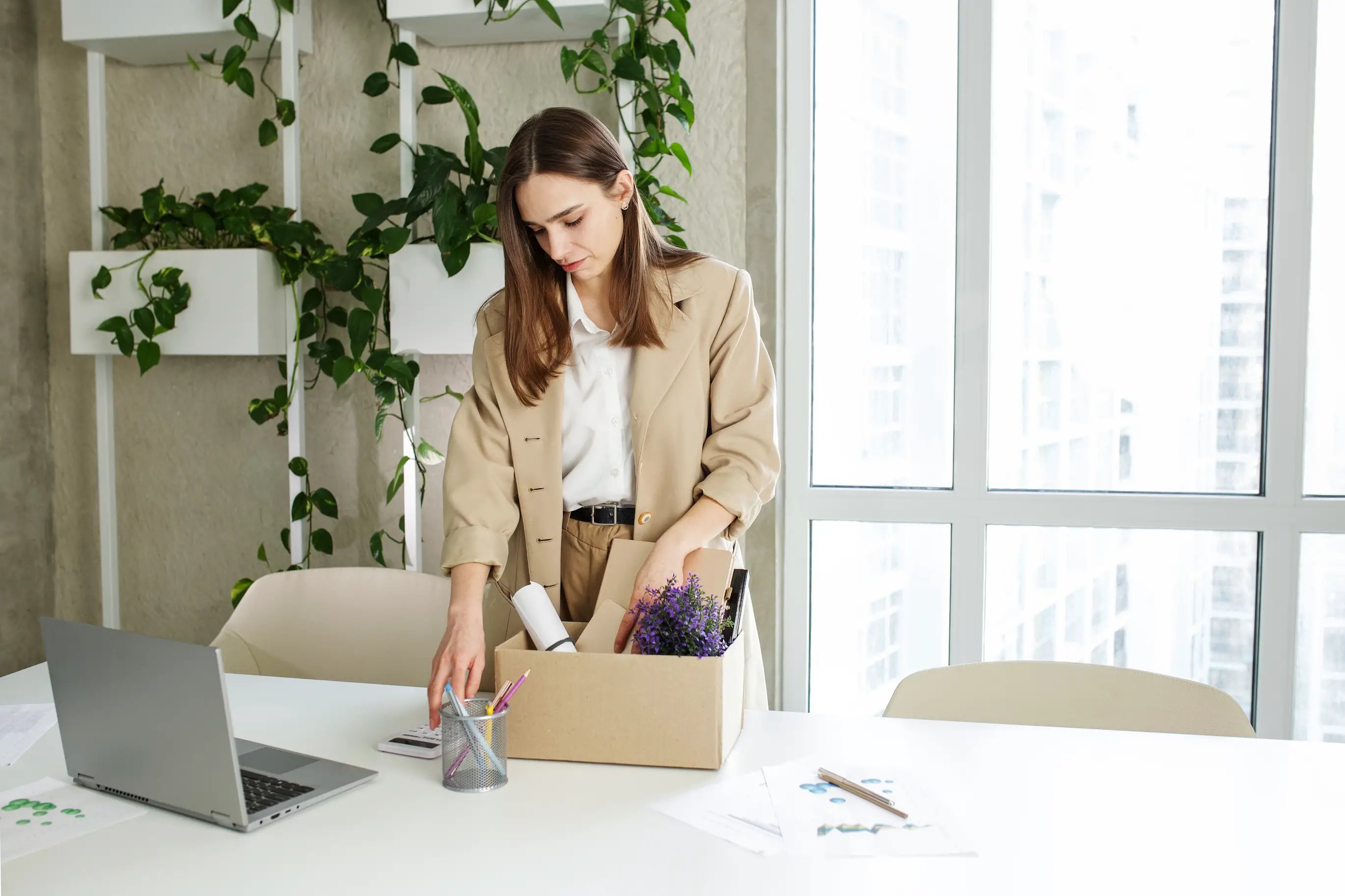 Dismissal. Fired frustrated employee woman packing belongings in cardboard box leaving workplace