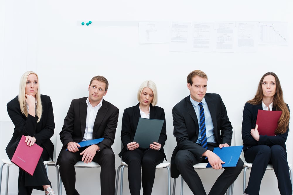 Group of applicants for a vacant post or corporate job sitting in a long line with folders containing their credentials carefully ignoring each other-3