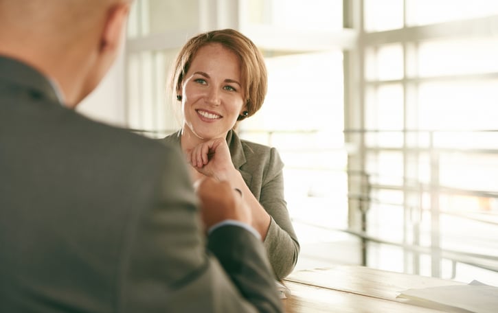 Empleado satisfecho recibiendo feedback positivo en un entorno de trabajo colaborativo.