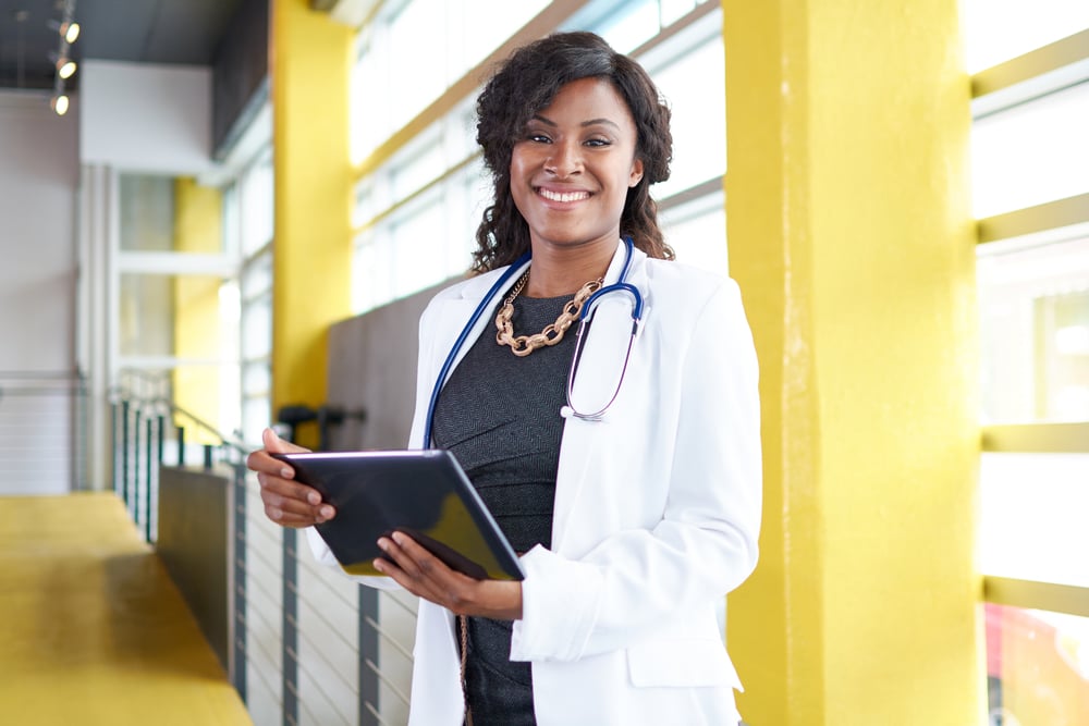 Portrait of a female doctor holding her patient chart on digital tablet in bright modern hospital-3