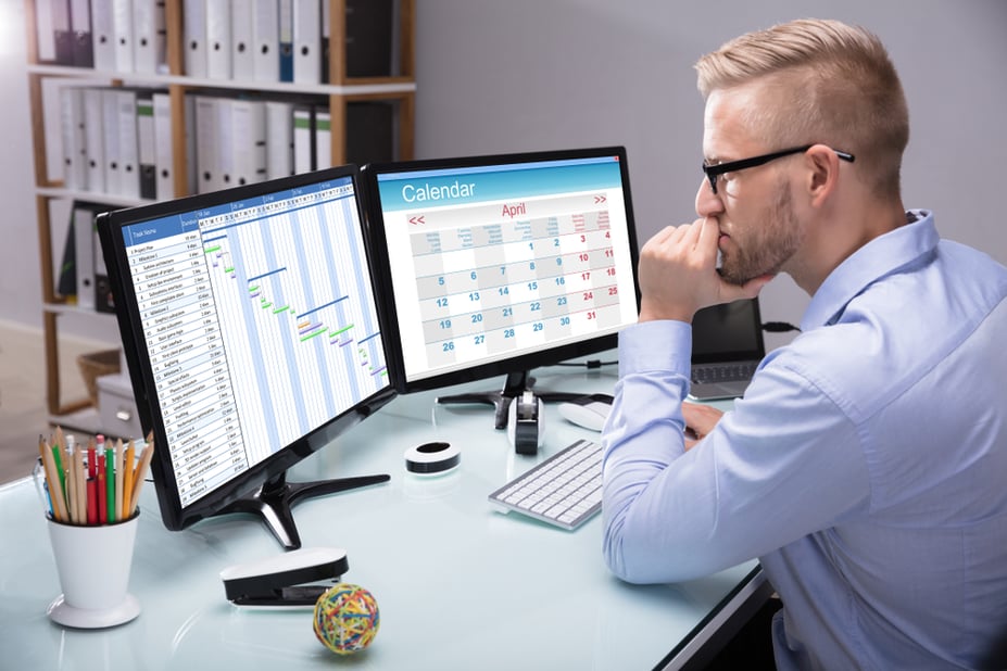 manager working on multi location employee schedules on laptop