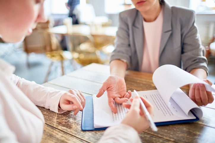 Empleador y empleado firmando un precontrato de trabajo en una oficina.