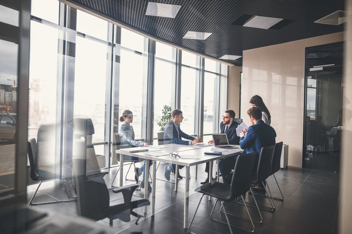 Grupo diverso de empleados colaborando en una reunión de trabajo.