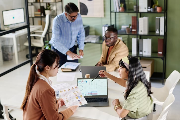 employees working together on centralised payroll system in office