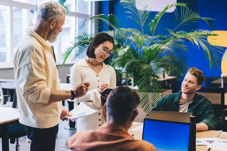 group of employees discussing their hybrid work schedules in office