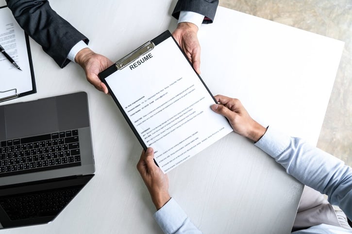 recruiters holding resume in hand using blind screening method