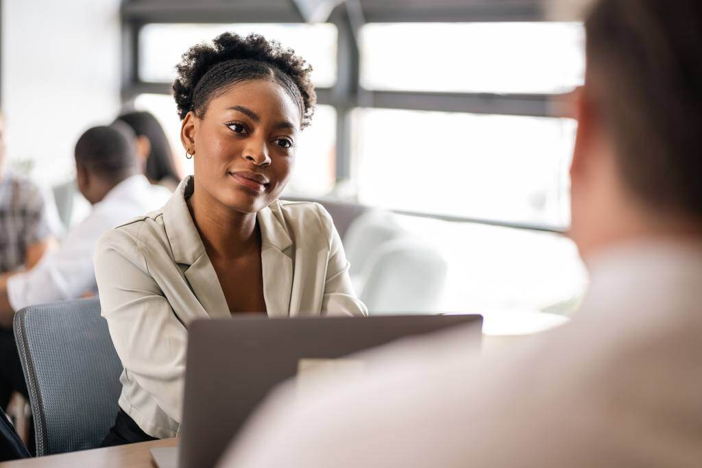 manager in meeting with new employee symbolising 90-day-review