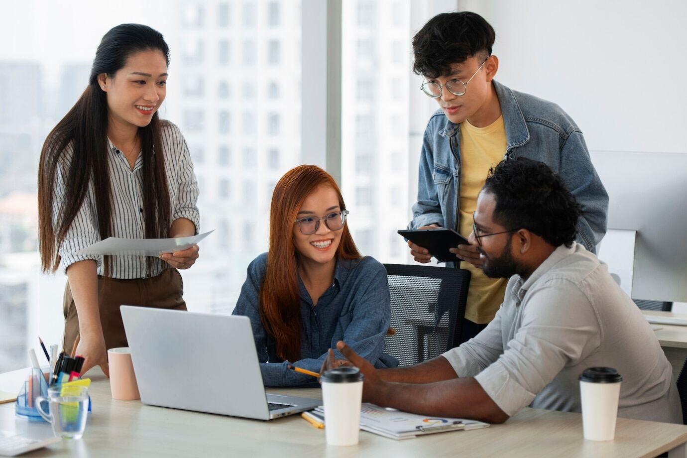 Gerentes y empleados colaborando en la implementación de cambios organizacionales en la empresa.