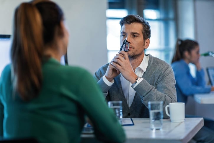 Arbeitgeber und Arbeitnehmer sitzen bei einem ernsten Gespräch über eine außerordentliche Kündigung.