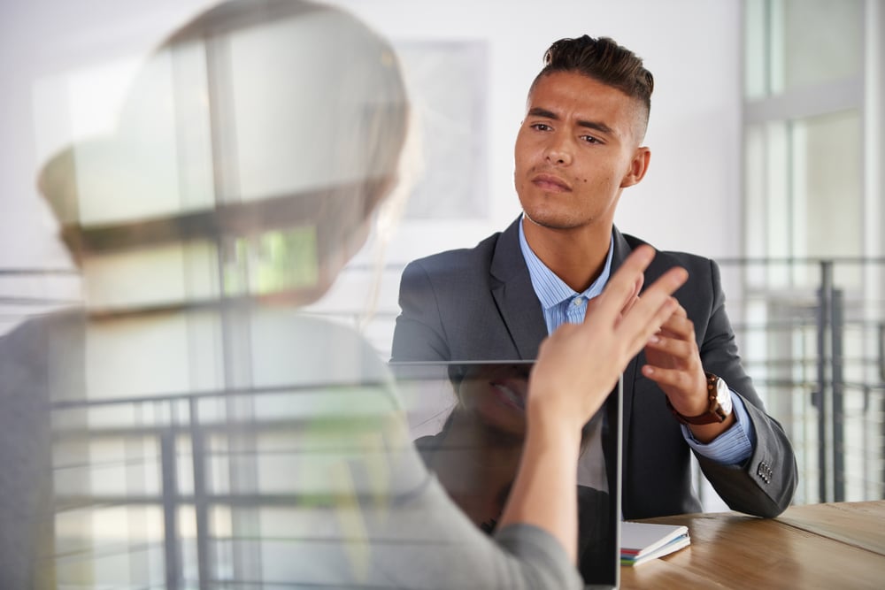 Arbeitsverhältnis: Arbeitnehmer und Arbeitgeber diskutieren über die Zusatzvereinbarung zum Arbeitsvertrag.