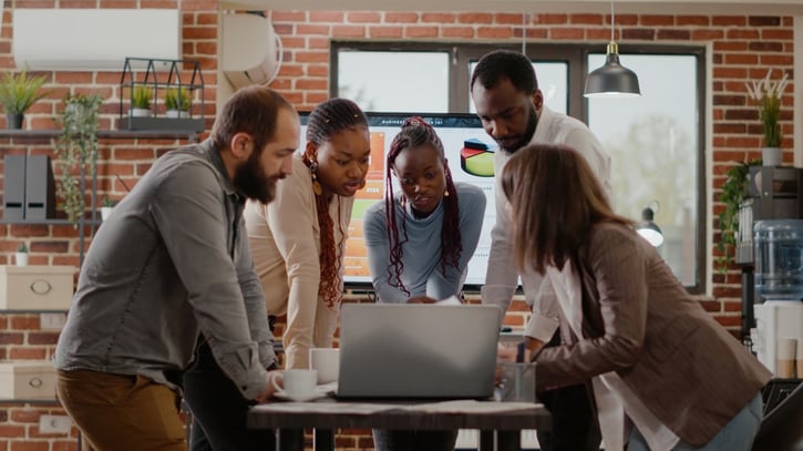 Engaged employees looking at project on laptop symbolising employee loyalty