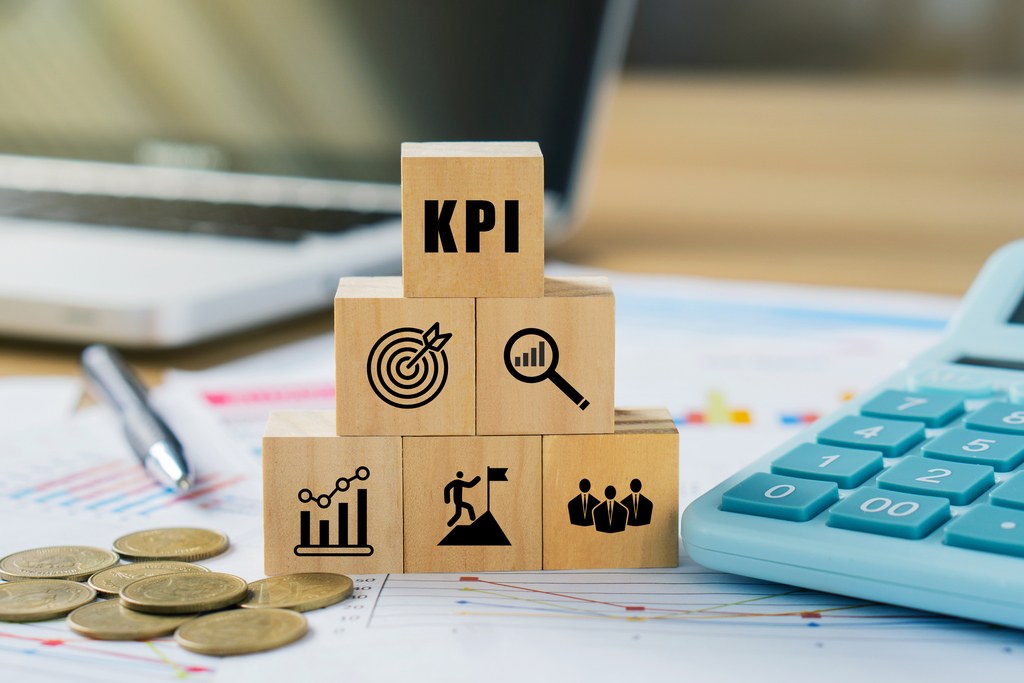 wooden blocks in pyramid with KPI symbols, symbolizing employee performance management