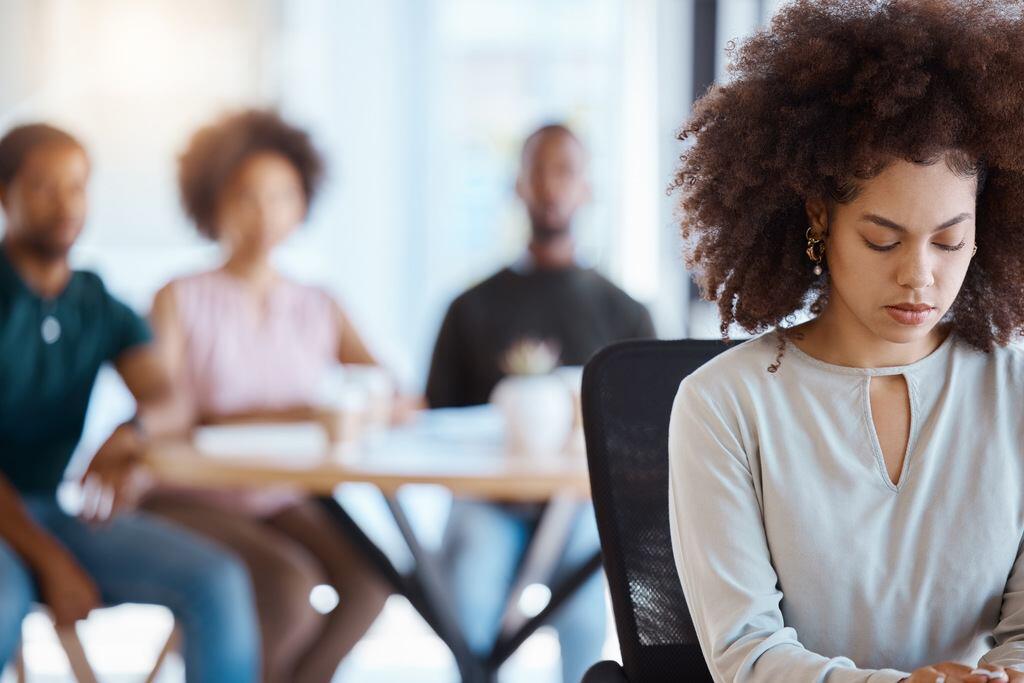 mujer enfrentando a la discriminación en el lugar de trabajo por parte de sus colegas