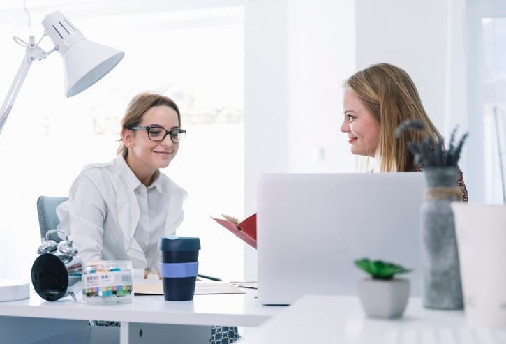 Büroangestellte diskutieren über Mitarbeiterbeteiligungspläne.